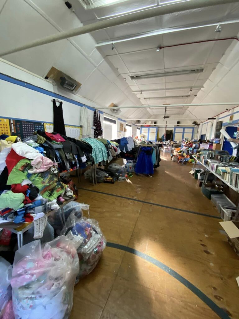 Inside the hall, with tables full of jumble sale merchandise set up for sale